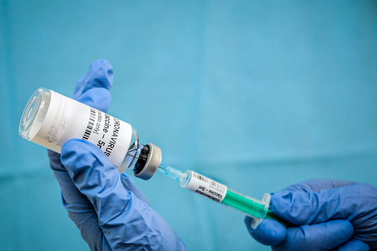 Infectious doctor fills injection syringe with CO-VID 19 vaccine - concept, for prevention, immunization and treatment for new corona virus infection(COVID-19,novel coronavirus disease 2019)