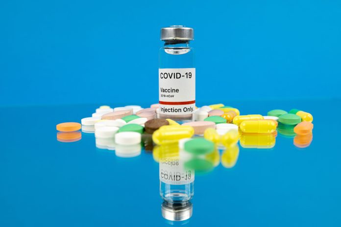pexels-photo-5995307-1 white labeled vaccine bottle on blue background