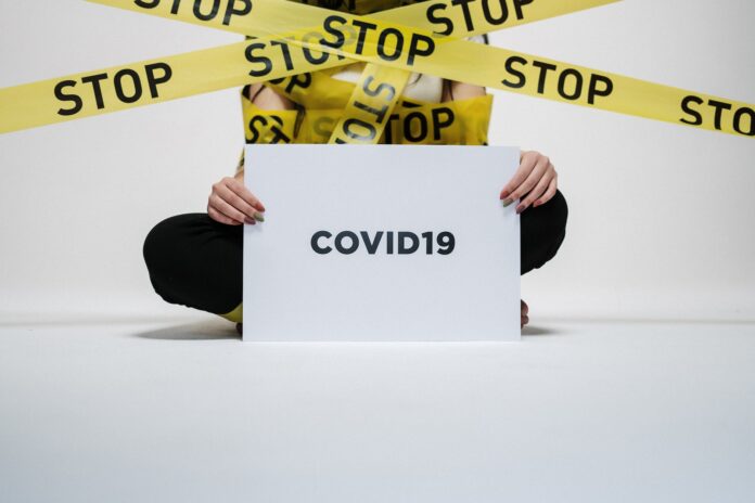 pexels-photo-3951600 person holding covid sign
