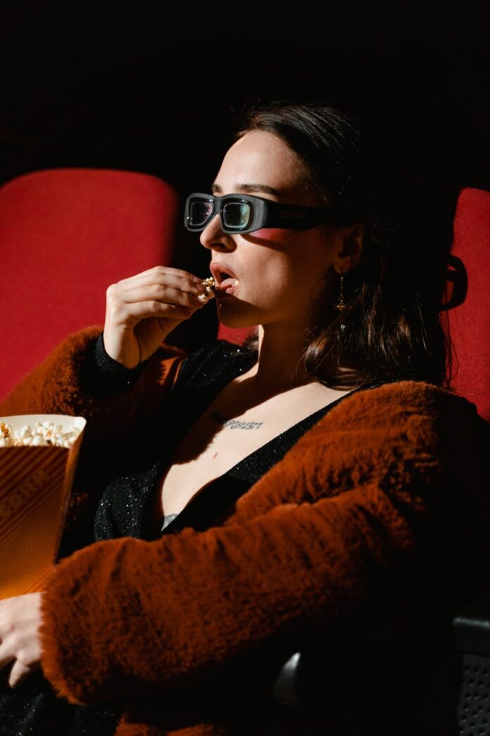 pexels-photo-7991314 a woman in brown jacket eating popcorn