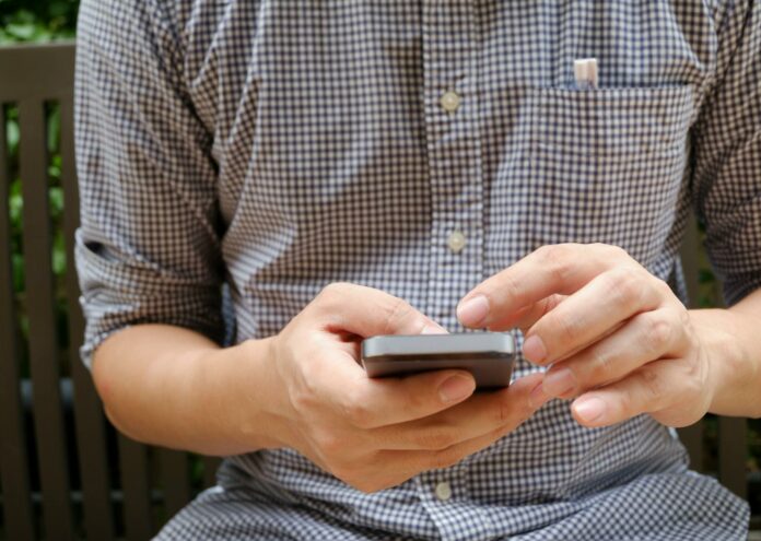 pexels-photo-346734 man in plaid shirt using smartphone
