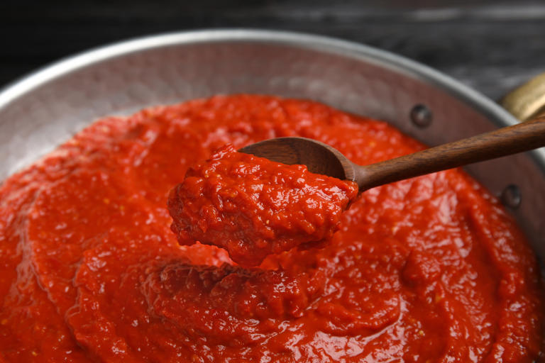 Modo de preparo – Passo 1* imagem meramente ilustrativaColoque em uma panela um pouco do molho de tomate. Por cima, acomode a massa.