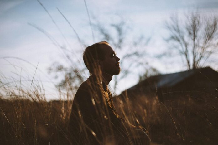 pexels-photo-775417 silhouette of man sitting on grass field at daytime