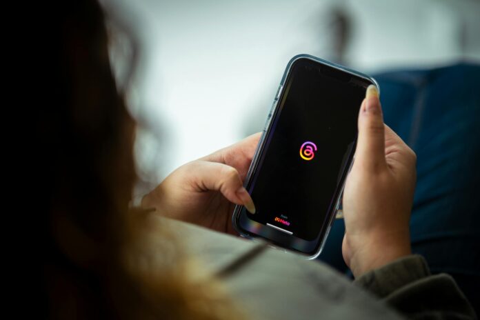 woman holding a smart phone and looking at a screen