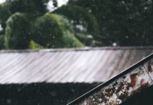 selective focus photography of corrugated metal sheet of house during rainy daytime