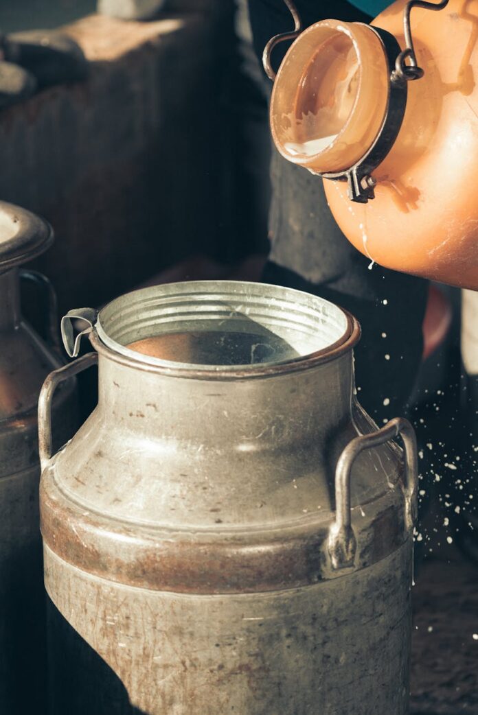 close up of milk being poured into a metal container