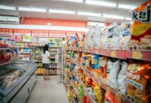 woman standing at end of aisle in supermarket