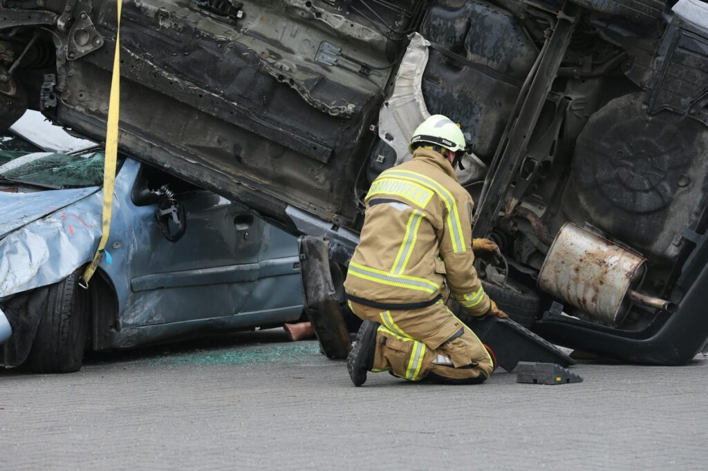 firefighter rescuing from overturned vehicle accident scene