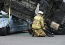firefighter rescuing from overturned vehicle accident scene