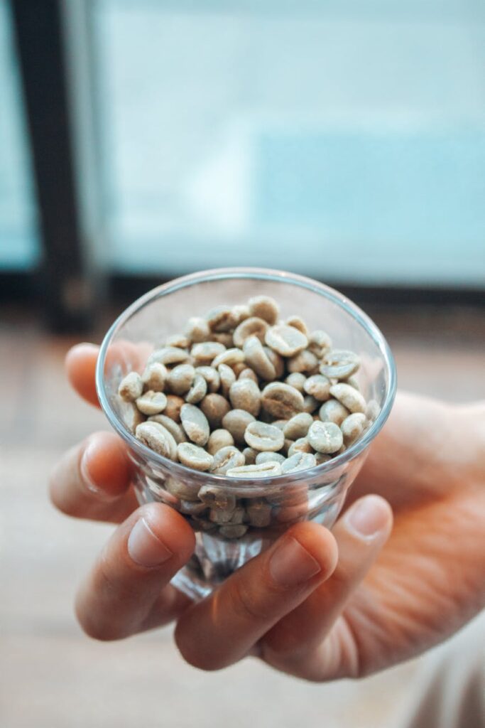 close up of unroasted coffee beans in a glass