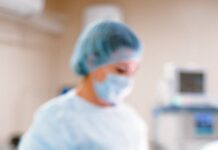 a person in blue scrub suit wearing white mask