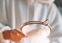 a person sifting powder into a bowl