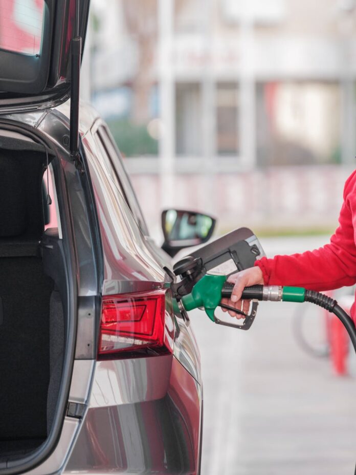 close up of a person refueling the car at a gas station