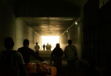 silhouettes in tunnel with bright exit