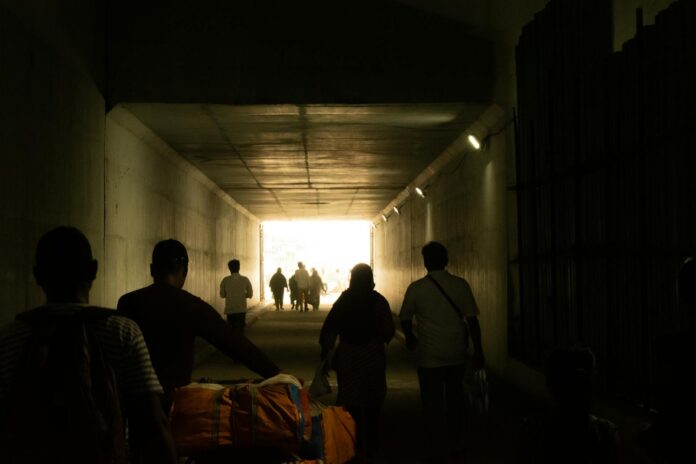 silhouettes in tunnel with bright exit