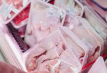 person holding raw meat on a tray