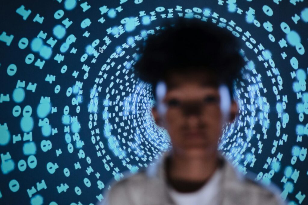 defocused photo of a young person standing on the background of a projection of numbers