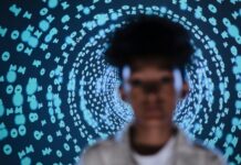 defocused photo of a young person standing on the background of a projection of numbers