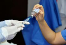close up of pouring liquid from bottle to syringe