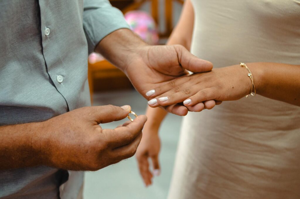 close up of hands exchanging wedding rings