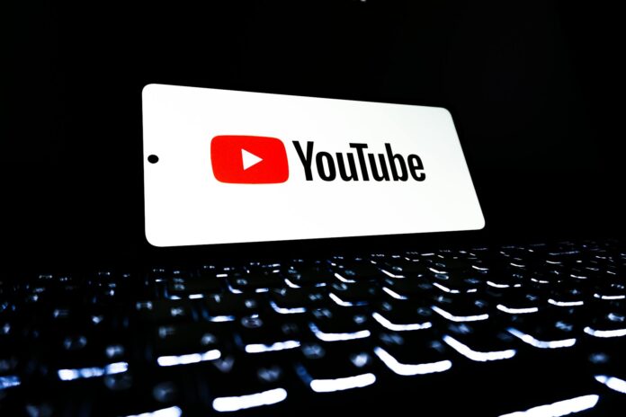 pexels-photo-33440447 youtube logo on smartphone over keyboard