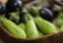 fresh green zucchini on plate with peeler