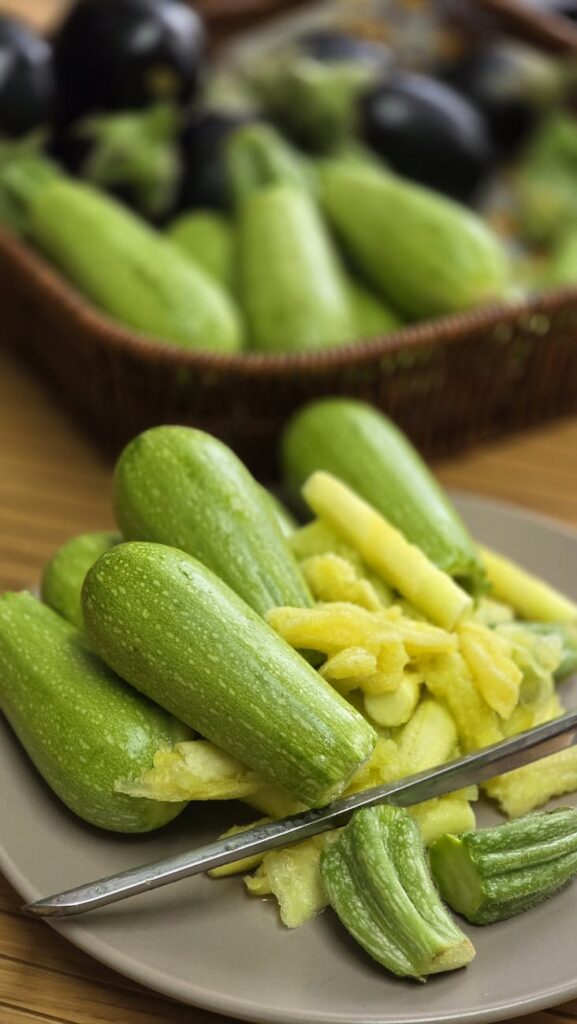 fresh green zucchini on plate with peeler