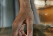 person holding white egg on brown wooden table
