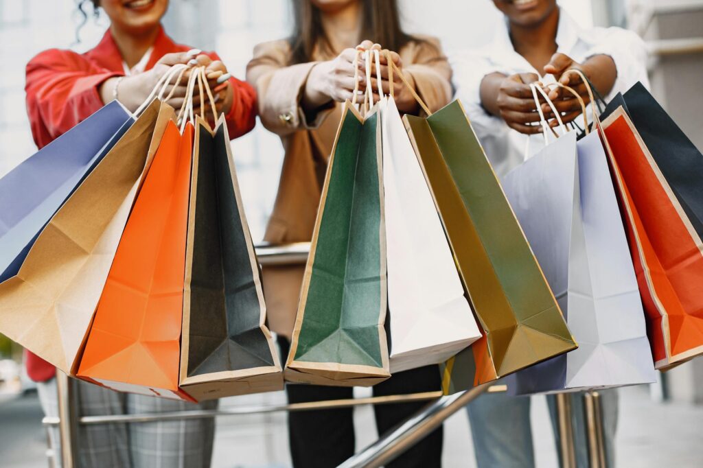 women holding colored paper bags