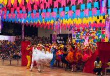 Você vai? Mais de 80% dos brasileiros adultos devem participar de comemorações de São João este ano dancers on a stage under vibrant colour decoration