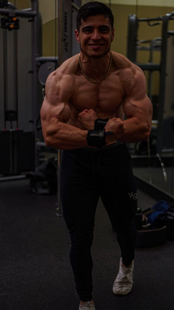 bodybuilder man flexing his muscles in a gym