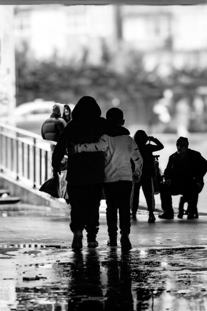 back view of boys hugging and walking