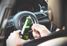 Mortes no trânsito causadas pela combinação álcool-direção diminuíram quase 20% em 14 anos person opening bottle on car
