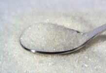 Preço do açúcar em tendência de queda nas usinas; safra de cana está no início close up of white sugar crystals on a spoon