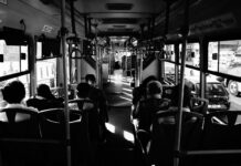 grayscale photo of people sitting inside a bus