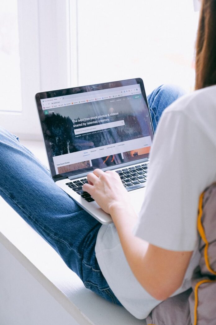 person in blue denim jeans using laptop